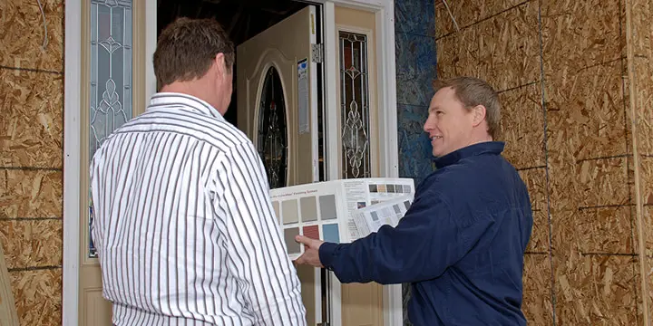 Employee showing samples to customers outside construction
