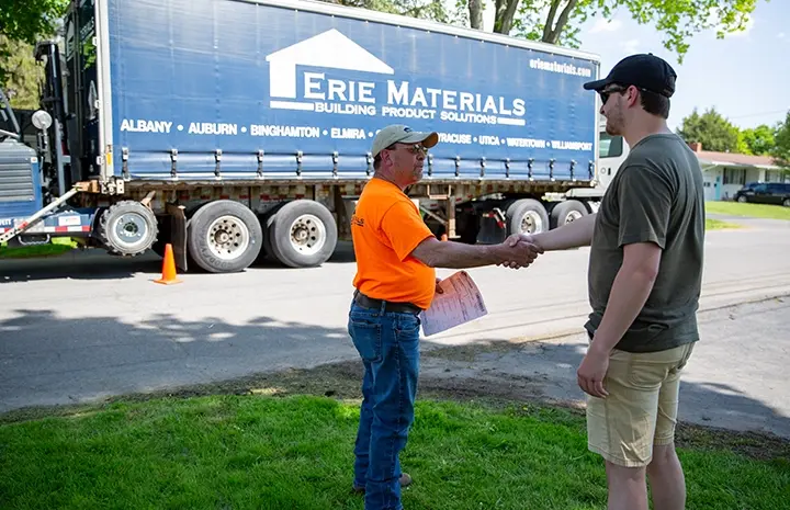 Employee shaking hands with a customer in front on an Erie Materials truck